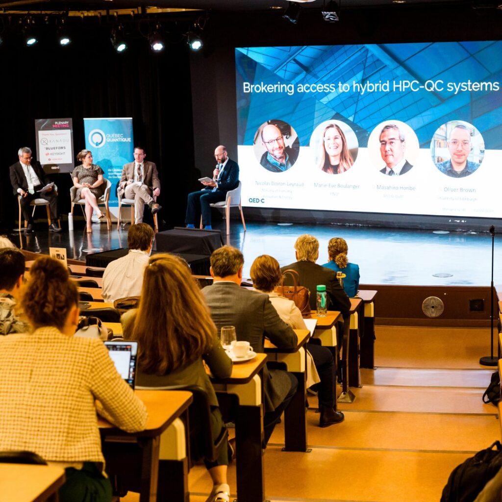 An audience listens to a panel discussion in an auditorium