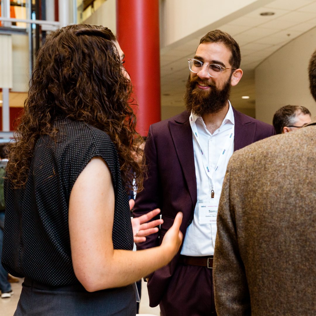 A man and a woman network at a QED-C Plenary meeting