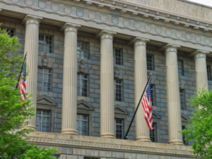 U.S. Department of Commerce building with columns and American flags